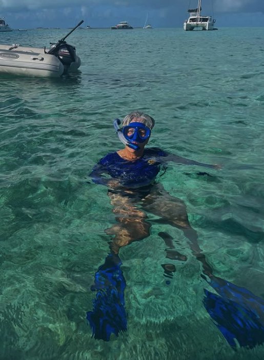 A snorkeler finning over turquoise water in the Bahamas